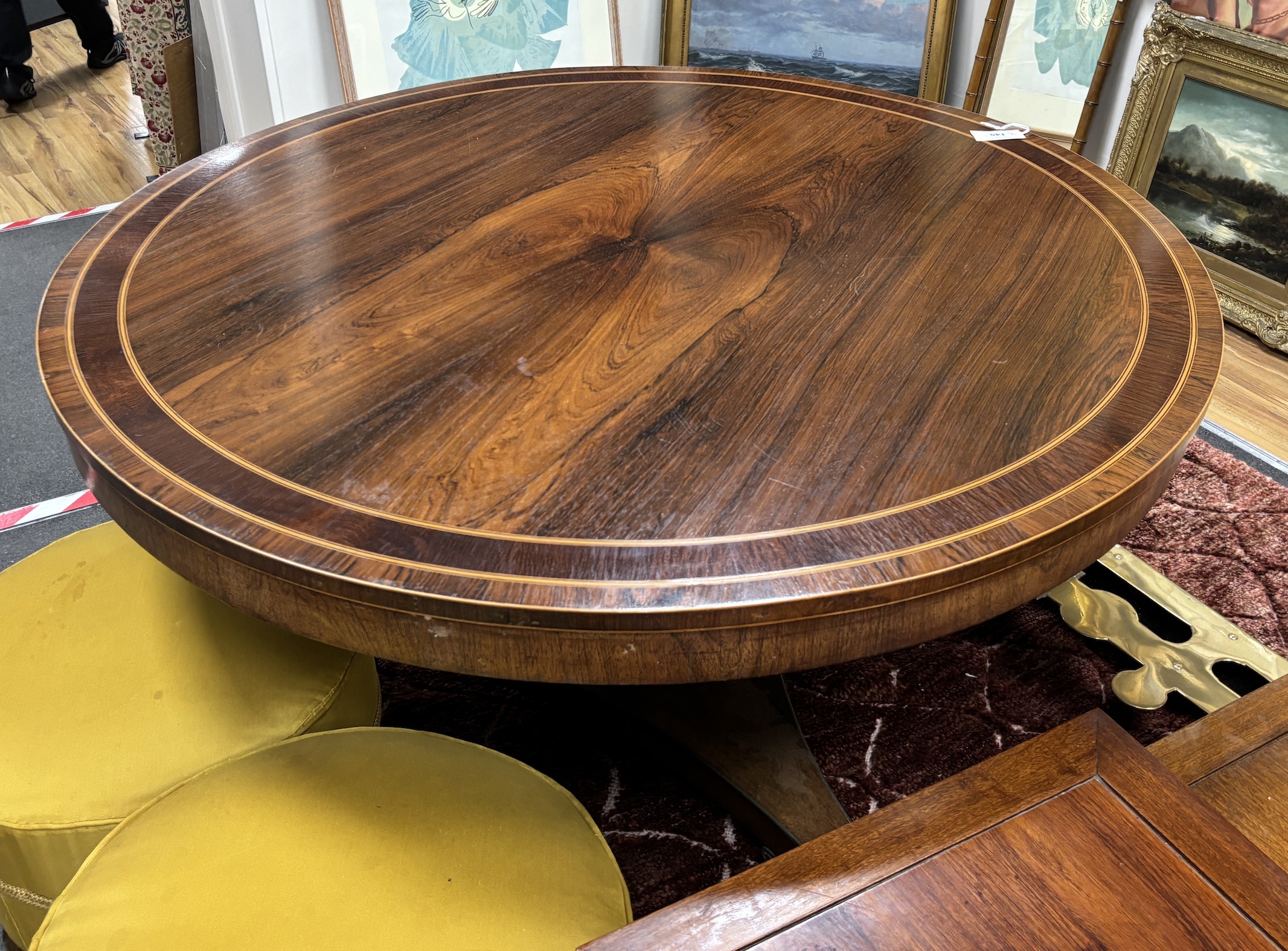 A Regency circular banded rosewood tilt top breakfast table on ormolu claw feet, diameter 132cm, height 73cm